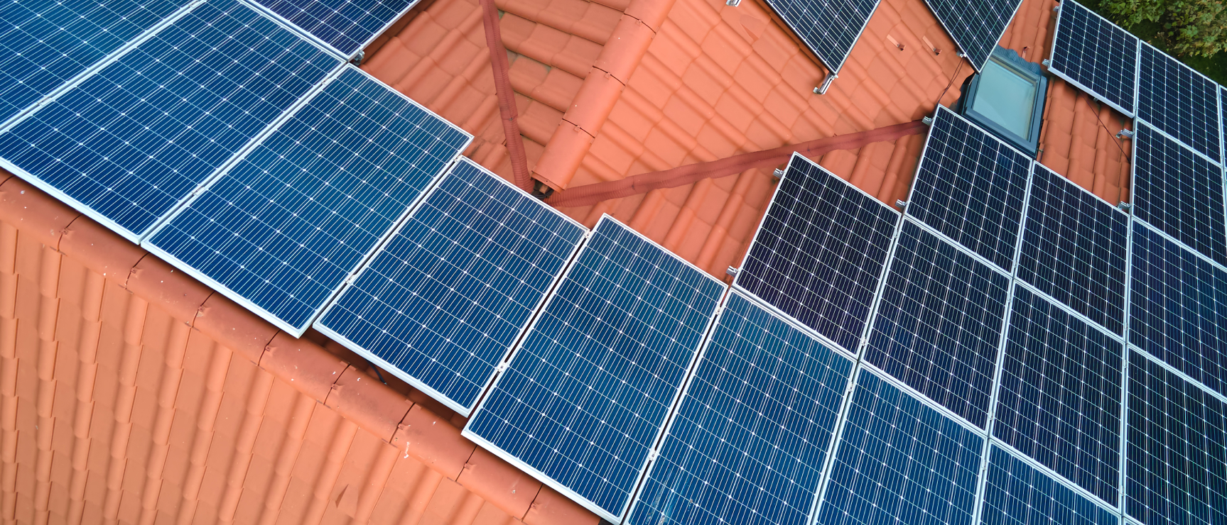 Aerial view of a home solar power system installed across a tiled rooftop