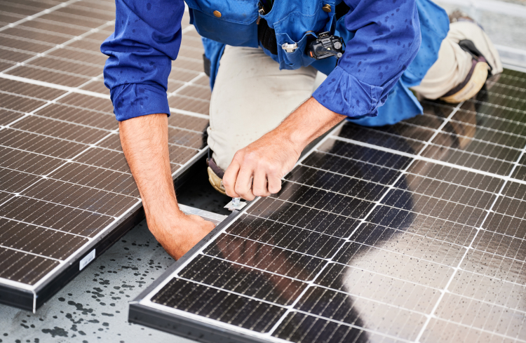 Technician securing a solar panel frame during installation