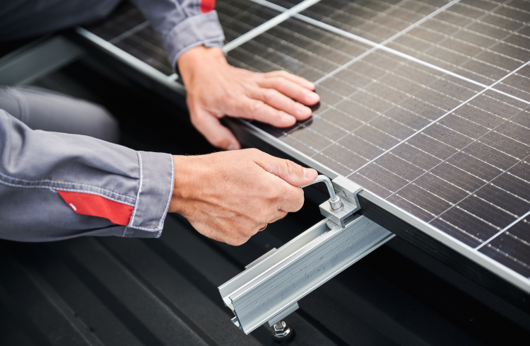 Technician fitting a mounting rail during solar panel installation
